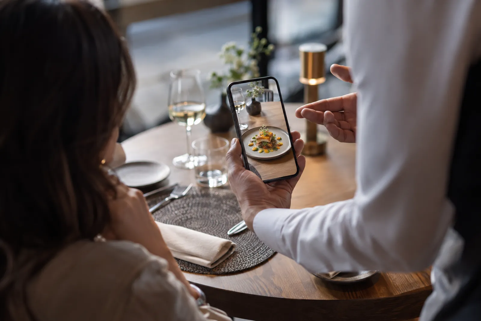 A waiter presenting the AR menu at the table